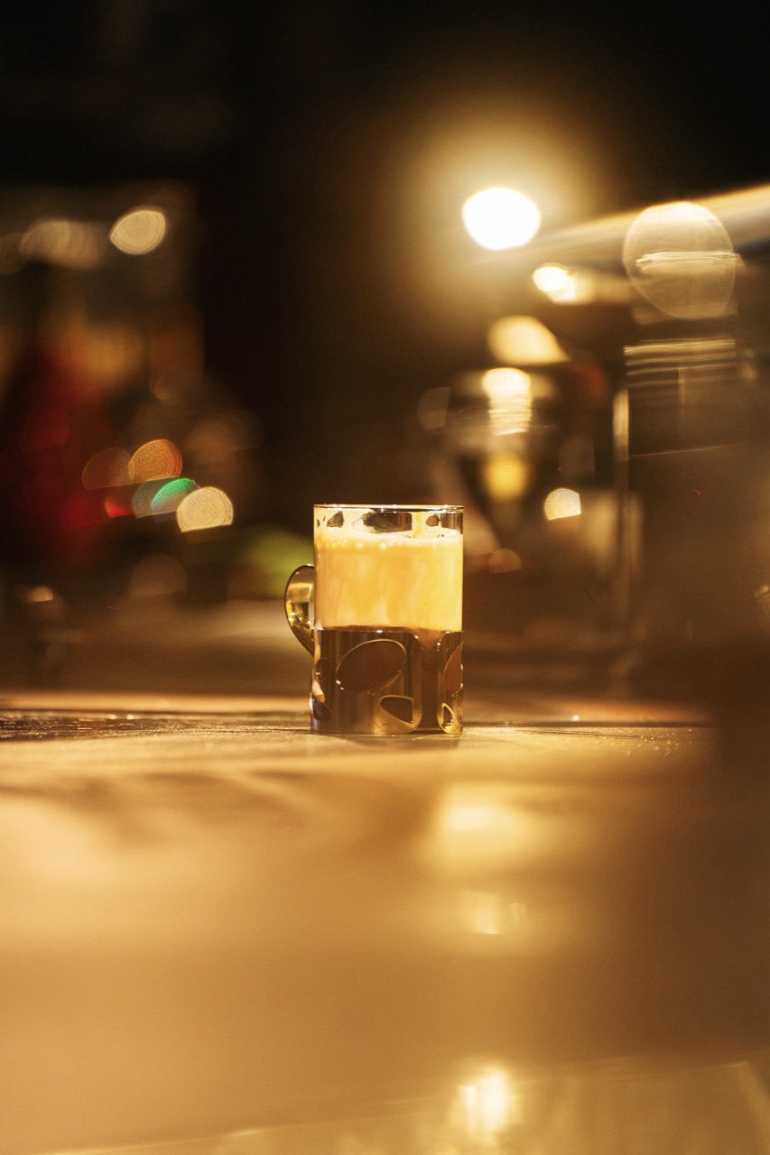 A short glass resting on the counter under warm light